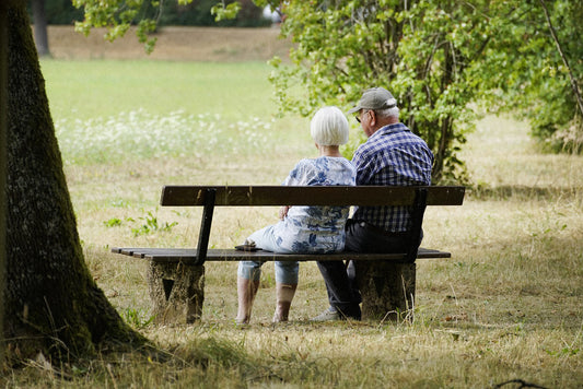 Couple d'aînés assis sur un banc de parc. 